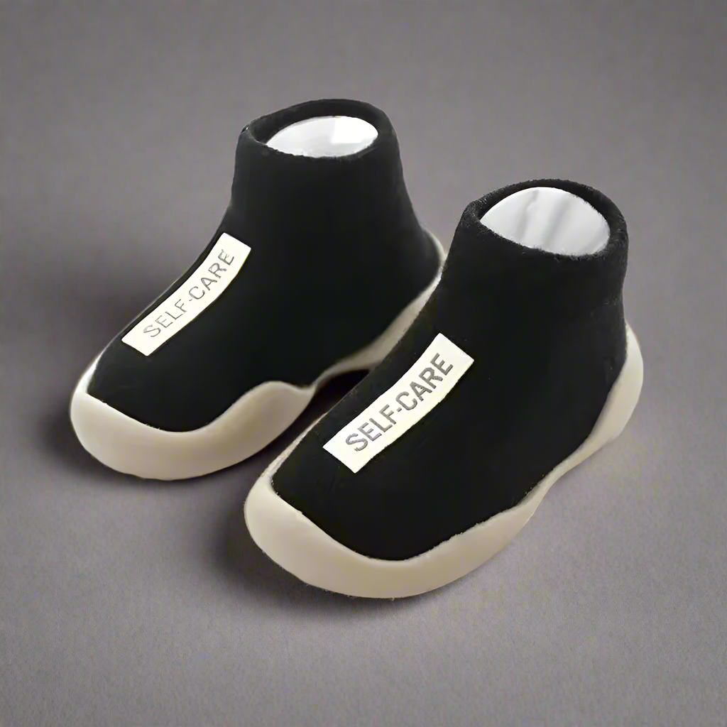 Black socks with 'SELF-CARE' label on a white background