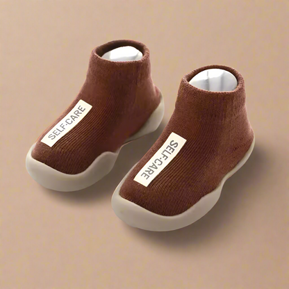 Pair of brown ankle boots with 'SELF-CARE' label on a white background