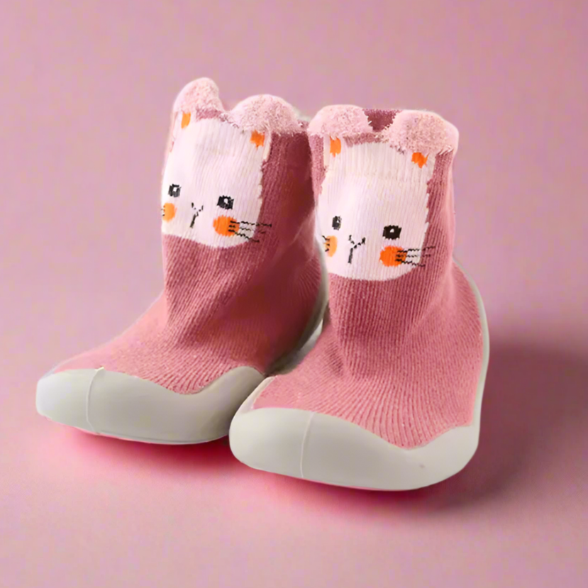 Pair of pink children's socks with bunny face design on a pink background